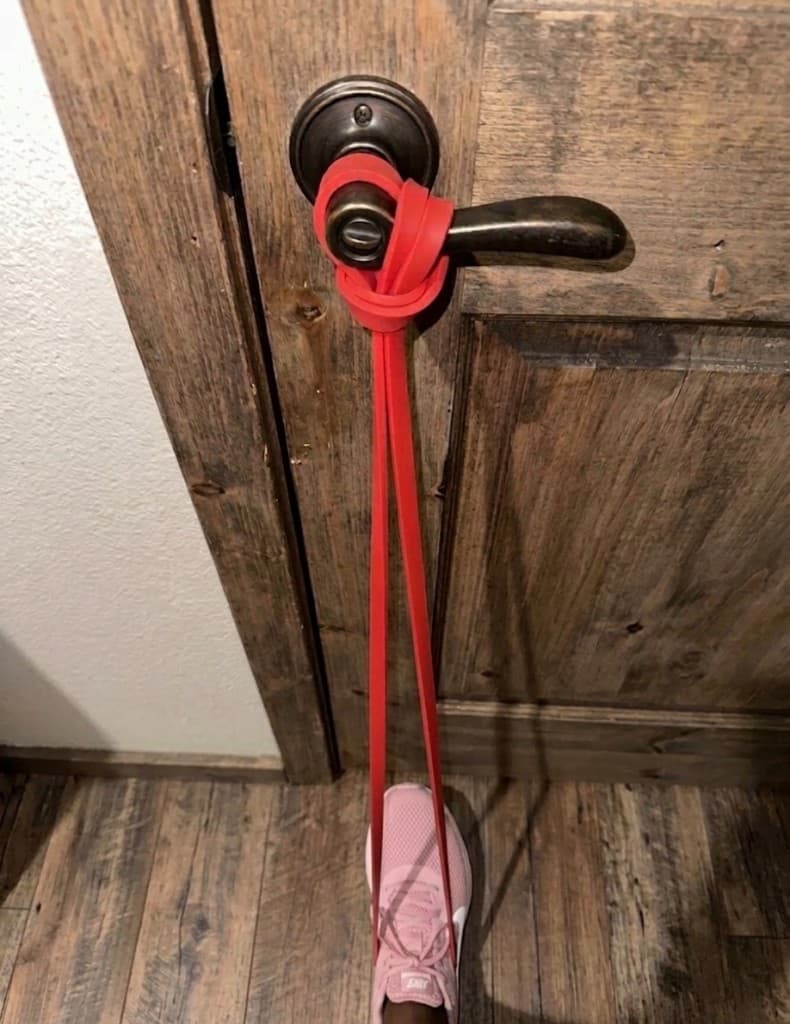 Ruck & Run resistance band anchored to a door for home training